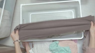 Güzel bir kız aracılığıyla ve kıyafetlerini soyunma odasina sepetler içinde pas geçiyor. sipariş getiriyor. yukarıdan görüntülemek