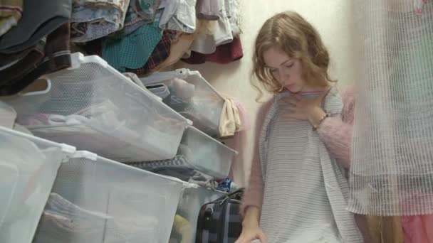 一个漂亮的女孩微笑着 整理和折叠在篮子里的衣服在她的更衣室 把东西按4K 的顺序排列 — 图库视频影像