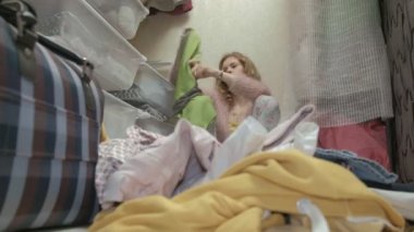 Güzel bir kız, yorgun genç bir anne soyunma odasina sepetleri giysiler dışarı atar, depresyona girmiş. amacıyla bir şeyler koyar