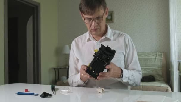 Un homme répare une cafetière d'une machine à café, atelier de réparation de cafetières 