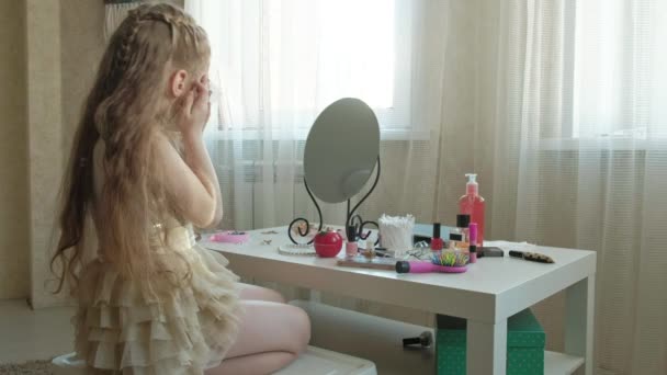 Malá dívka s červenými vlasy dívá do zrcadla, čistí pokožku obličeje s vlhčené ubrousky, make-up, obličej, móda, styl, kosmetika — Stock video