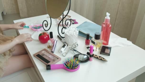 Malá dívka s červenými vlasy vybere kosmetika, vypadá v zrcadlo, make-up, obličej, móda, styl, kosmetika — Stock video