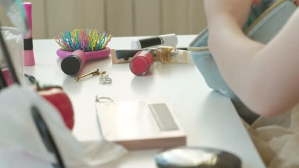 Menina com cabelo vermelho coloca maquiagem de um saco cosmético, olha no espelho, maquiagem, rosto, moda, estilo, cosméticos, close-up — Vídeo de Stock