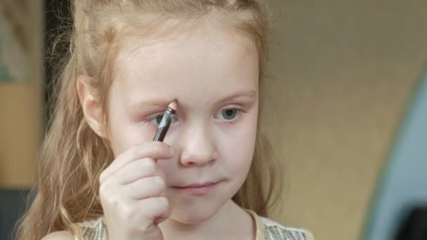 Liten flicka med rött hår drar ögonbrynen med ögonbrynspenna, ser ut i spegeln, makeup, ansikte, mode, stil, kosmetika, närbild — Stockvideo