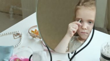 Kızıl saçlı küçük kız kaş kalemi ile kaşları çizer, ayna, makyaj, yüz, moda, stil, kozmetik, yakın çekim görünüyor