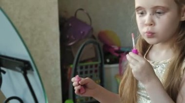 Kızıl saçlı küçük kız parlak ruj dudakları koyar, ayna, makyaj, yüz, moda, stil, kozmetik, portre görünüyor