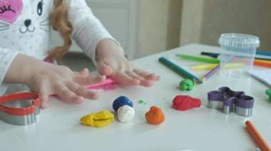 küçük bir kız oyun hamuru ile elleriyle alır, orada rakamlar ve renkli kalemler Masaüstü, ince motor becerileri geliştirme
