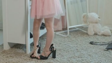 pigtails pembe bir etek ile neşeli küçük kız anne ayakkabı topuklu ayakkabı ve çanta, anneler dolap 4 k bir ayna önünde dans üzerinde çalışır