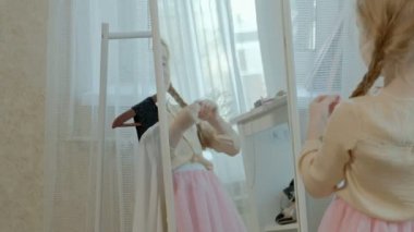 pigtails pembe bir etek ile neşeli küçük kız benim anne gardırop önlemler aynanın önünde el Yüzüklerin koyar