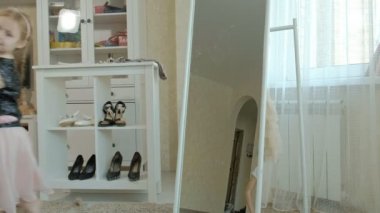 bir aynanın önünde dans neşeli kız çalışan yetişkin anneler kıyafetler, elbiseler, yüksek topuklar, pigtails ile gardırop anneler