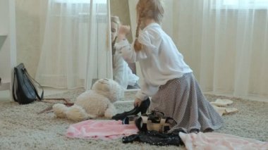 Yetişkin anneler elbise, elbise, topuklu ve dansları bir çanta, anneler gardırop bir ayna önünde neşeli kız pigtails pembe bir etek ile çalışır
