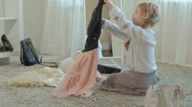 Yetişkin anneler elbise, elbise, topuklu ve dansları bir çanta, anneler gardırop bir ayna önünde neşeli kız pigtails pembe bir etek ile çalışır