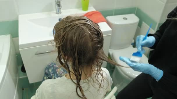Kadın Kuaför renk ustası evde banyoda genç bir kadının saçının boya koyar, bir fırça ile boya geçerlidir saç, Güzellik, moda — Stok video