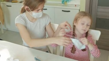 Genç kadın ve kız tıbbi maske, anne ve kızı koymak