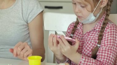 Genç bir kadın ve bir kız dişlerini gelen hamuru kalıp, dişlerini bir oyuncak çene içine yerleştirin, diş hekimi, anne ve kızı oynamak