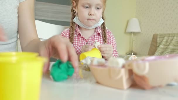 A young woman and a girl mold their teeth from plasticine, insert their teeth into a toy jaw, play a dentist, mother and daughter — Stock Video