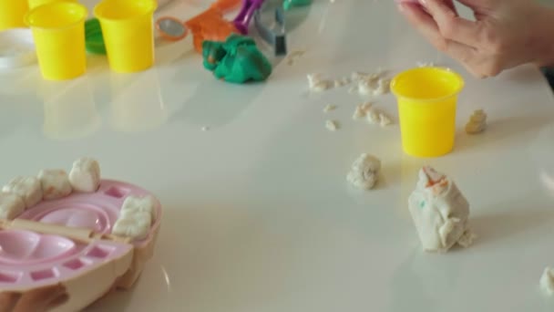 Eine junge Frau und ein Mädchen formen ihre Zähne aus Knetmasse, stecken ihre Zähne in einen Spielzeugkiefer, spielen Zahnarzt, Mutter und Tochter — Stockvideo