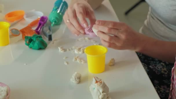 Une jeune femme et une fille moulent leurs dents à partir de la plasticine, insèrent leurs dents dans une mâchoire de jouet, jouent un dentiste, mère et fille — Video