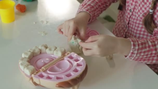 Молода жінка і дівчина формують зуби з пластиліну, вставляють зуби в щелепу іграшки, грають у стоматолога, матір і доньку — стокове відео