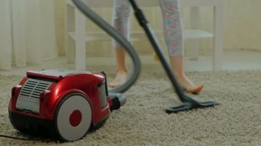 Anne ve kızı, bir elektrik süpürgesi ile genç bir kadın temizler, sarı saçlı küçük bir kız oyuncaklar, bir kap içinde yardımcı olur anne Tasarımcısı toplar.