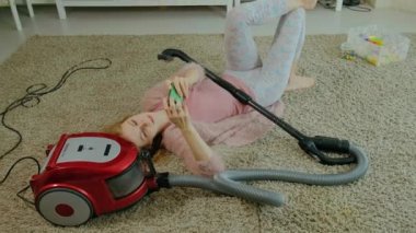 mutlu genç kadın ya da yarı-kulaklıklar, yalan ev hanımı bir elektrikli süpürge ile telefon kullanır, müzik, dinliyor dansları, Temizleme, kat hizmetleri