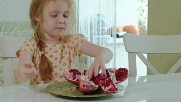 Niña feliz con el pelo rubio come granada, concepto de comida saludable, retrato de cerca — Vídeos de Stock