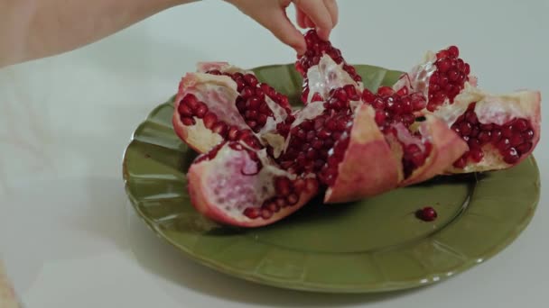 Glad liten tjej med blont hår äter granatäpple, hälsosam matkoncept, närbild — Stockvideo
