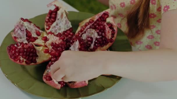 Felice bambina con i capelli biondi mangia melograno, concetto di cibo sano, primo piano — Video Stock