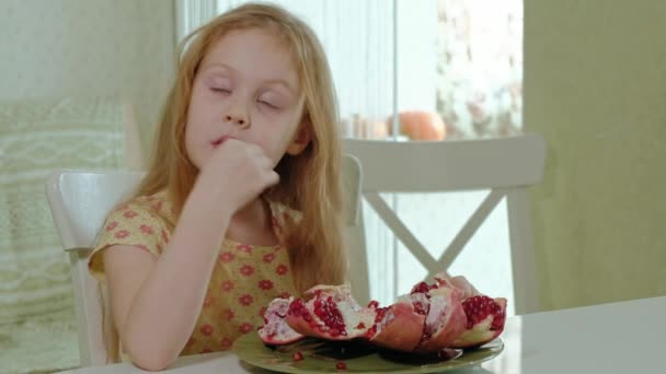 Niña feliz con el pelo rubio come granada, concepto de comida saludable, retrato de cerca — Vídeos de Stock