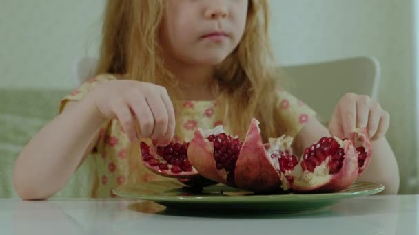 Felice bambina con i capelli biondi mangia melograno, concetto di cibo sano, ritratto ravvicinato — Video Stock