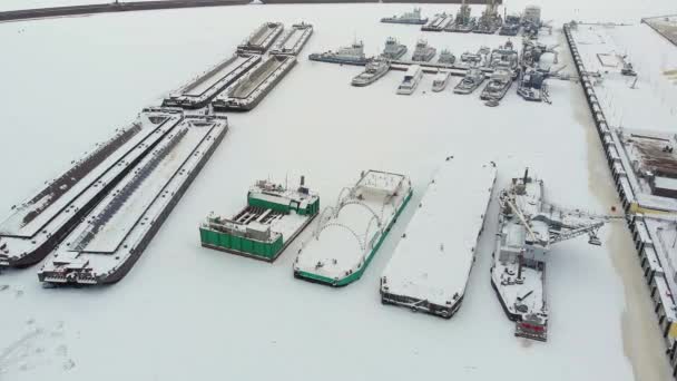 Речной порт, стоянка грузовых судов, судно с краном, зима, аэросъемка, вид сверху — стоковое видео