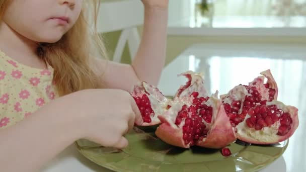 Niña feliz con el pelo rubio come granada, concepto de comida saludable, retrato de cerca — Vídeos de Stock