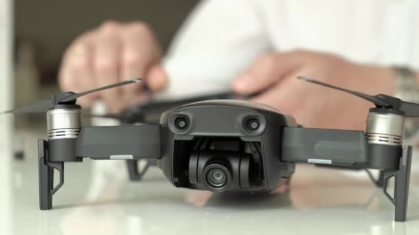 Zralý muž s brýlemi a bílou košili sestavuje ovládací panel pro quadrocopter, koncept pro studium technologií, detail ruky — Stock video