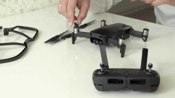 Mogen man med glasögon och en vit skjorta monterar en quadrocopter, förändringar blad, begreppet studerar teknik, närbild — Stockvideo