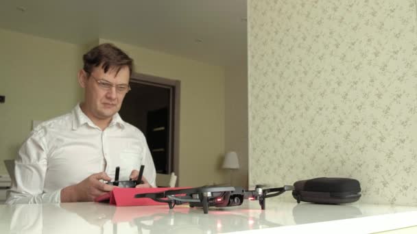 Hombre maduro en gafas y camisa blanca controla quadcopter desde la consola, vuelo de prueba, el concepto de estudiar tecnología — Vídeos de Stock