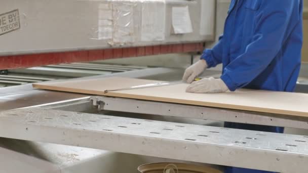 Un hombre sierra los espacios en blanco de madera de la puerta en la máquina, la producción de puertas interiores del pueblo — Vídeo de stock