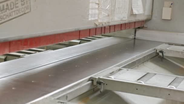 un homme scie des flans de porte en bois sur la machine, la production de portes intérieures de village 