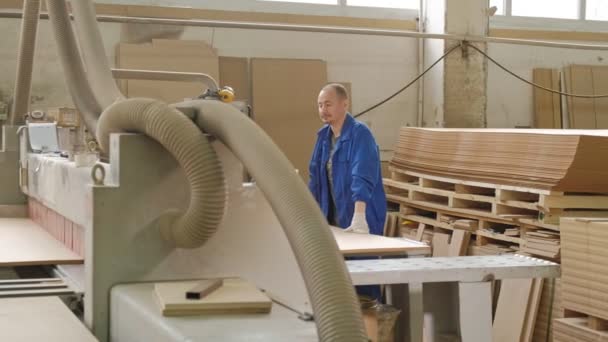 Ein Mann sägt hölzerne Türrohlinge an der Maschine, die Herstellung von Dorfinnentüren — Stockvideo