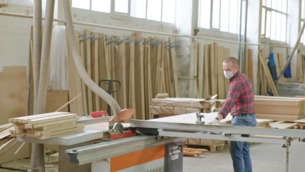 Een man zagen houten deur spaties op de machine, de productie van dorp binnendeuren — Stockvideo