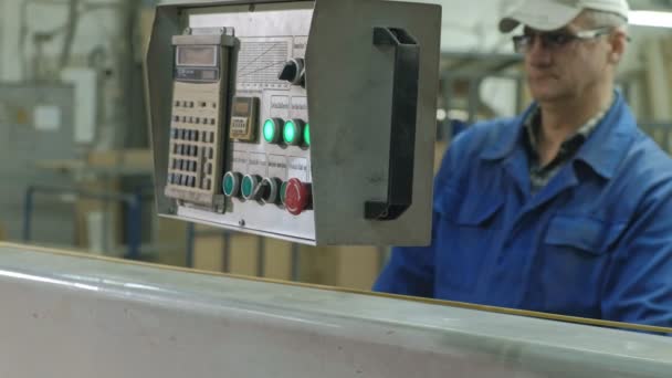 Un hombre sierra los espacios en blanco de madera de la puerta en la máquina, la producción de puertas interiores del pueblo — Vídeos de Stock