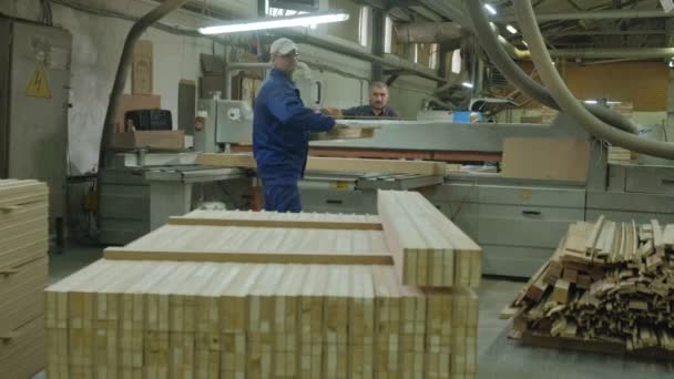 Un hombre sierra los espacios en blanco de madera de la puerta en la máquina, la producción de puertas interiores del pueblo — Vídeos de Stock