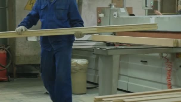 Un uomo sega grezzi porta in legno sulla macchina, la produzione di porte interne del villaggio — Video Stock