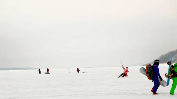 CHEBOKSARY, RUSIA - 31 DE DICIEMBRE DE 2018: Los atletas de snowkiting cabalgan en el río en trajes de Papá Noel en invierno — Vídeos de Stock