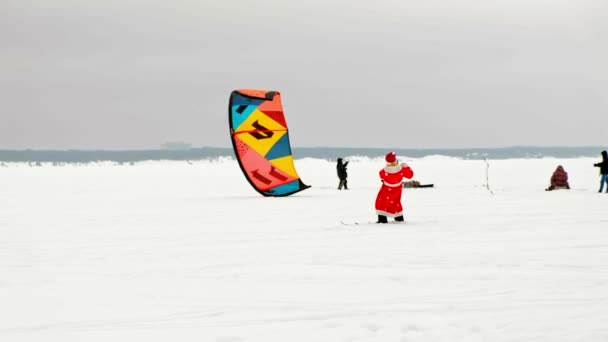 CHEBOKSARY, RÚSSIA - DEZEMBRO 31, 2018: snowkiting atletas passeio no rio em trajes de Papai Noel no inverno — Vídeo de Stock
