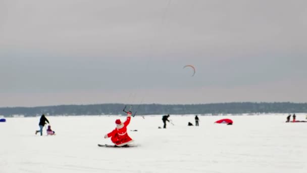 CHEBOKSARY, RUSSIA - DECEMBER 31, 2018: snowkiting athletes ride on the river in Santa Claus costumes in winter — Stock Video