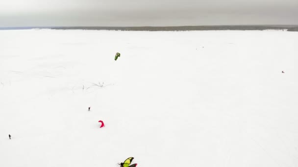 CHEBOKSARY, RUSIA - 31 DE DICIEMBRE DE 2018: Atletas involucrados en el snowkiting, en el paseo de invierno en el río con los disfraces de Santa Claus, fotografía aérea de un quadrocopter — Vídeo de stock