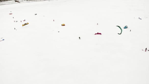 CHEBOKSARY, RÚSSIA - DEZEMBRO 31, 2018: Atletas envolvidos em snowkiting, no passeio de inverno no rio nos trajes do Papai Noel, fotografia aérea de um quadricóptero — Vídeo de Stock