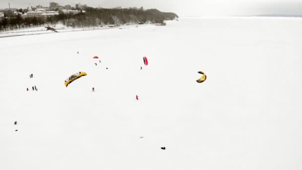 Чебоксари, Росія - 31 грудня 2018 роки: Спортсмени беруть участь у snowkiting, зима їзду на річці в костюмах Діда Мороза, Аерофотозйомка від на quadrocopter — стокове відео