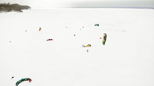 CHEBOKSARY, RUSIA - 31 DE DICIEMBRE DE 2018: Atletas involucrados en el snowkiting, en el paseo de invierno en el río con los disfraces de Santa Claus, fotografía aérea de un quadrocopter — Vídeo de stock