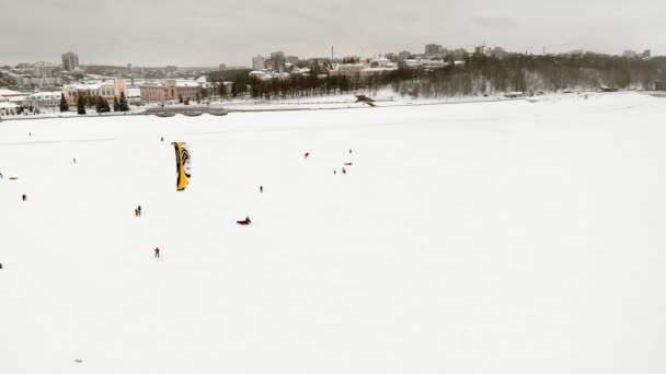 CHEBOKSARY, RUSIA - 31 DE DICIEMBRE DE 2018: Atletas involucrados en el snowkiting, en el paseo de invierno en el río con los disfraces de Santa Claus, fotografía aérea de un quadrocopter — Vídeo de stock
